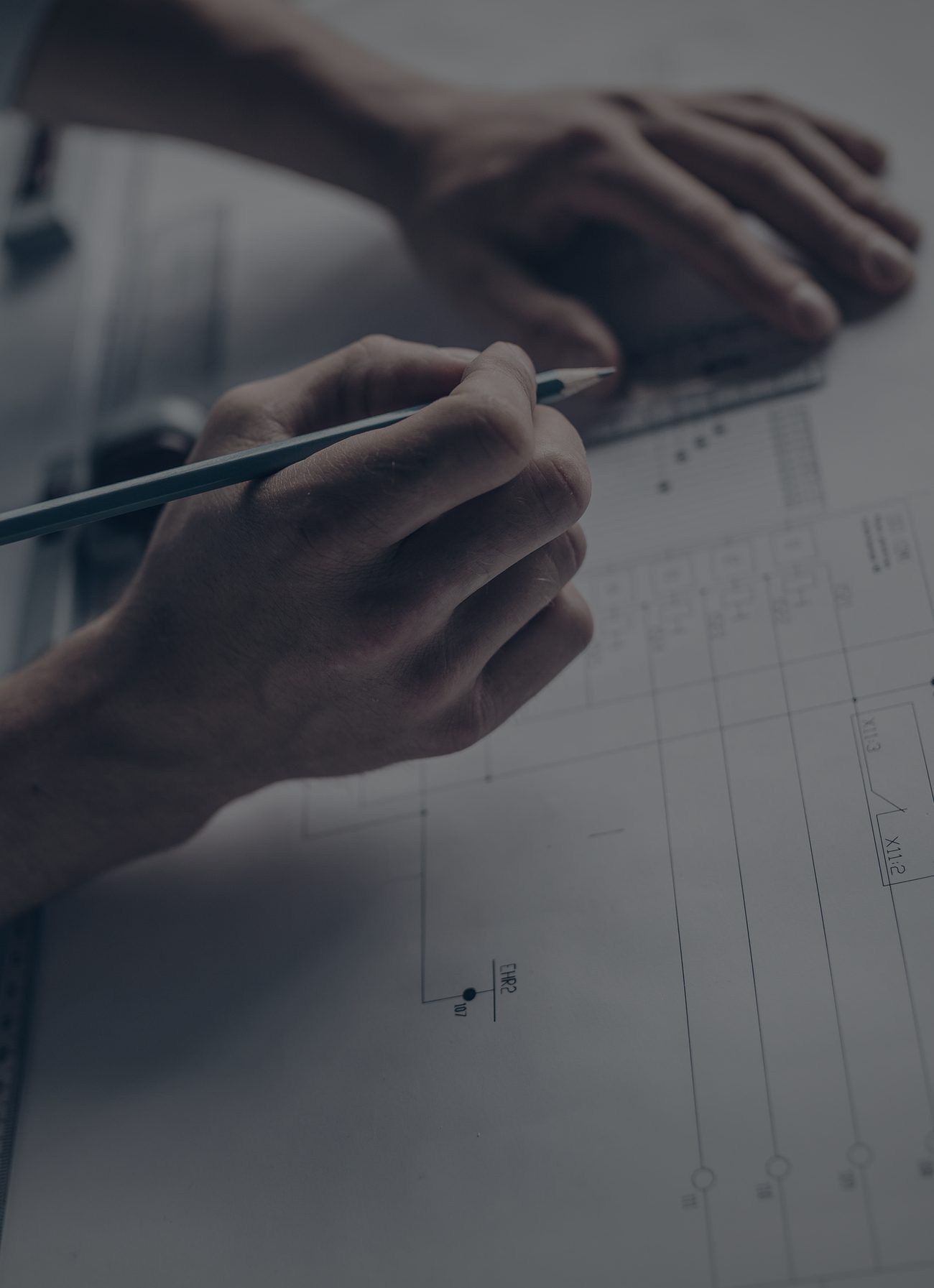 Hands drafting technical blueprints