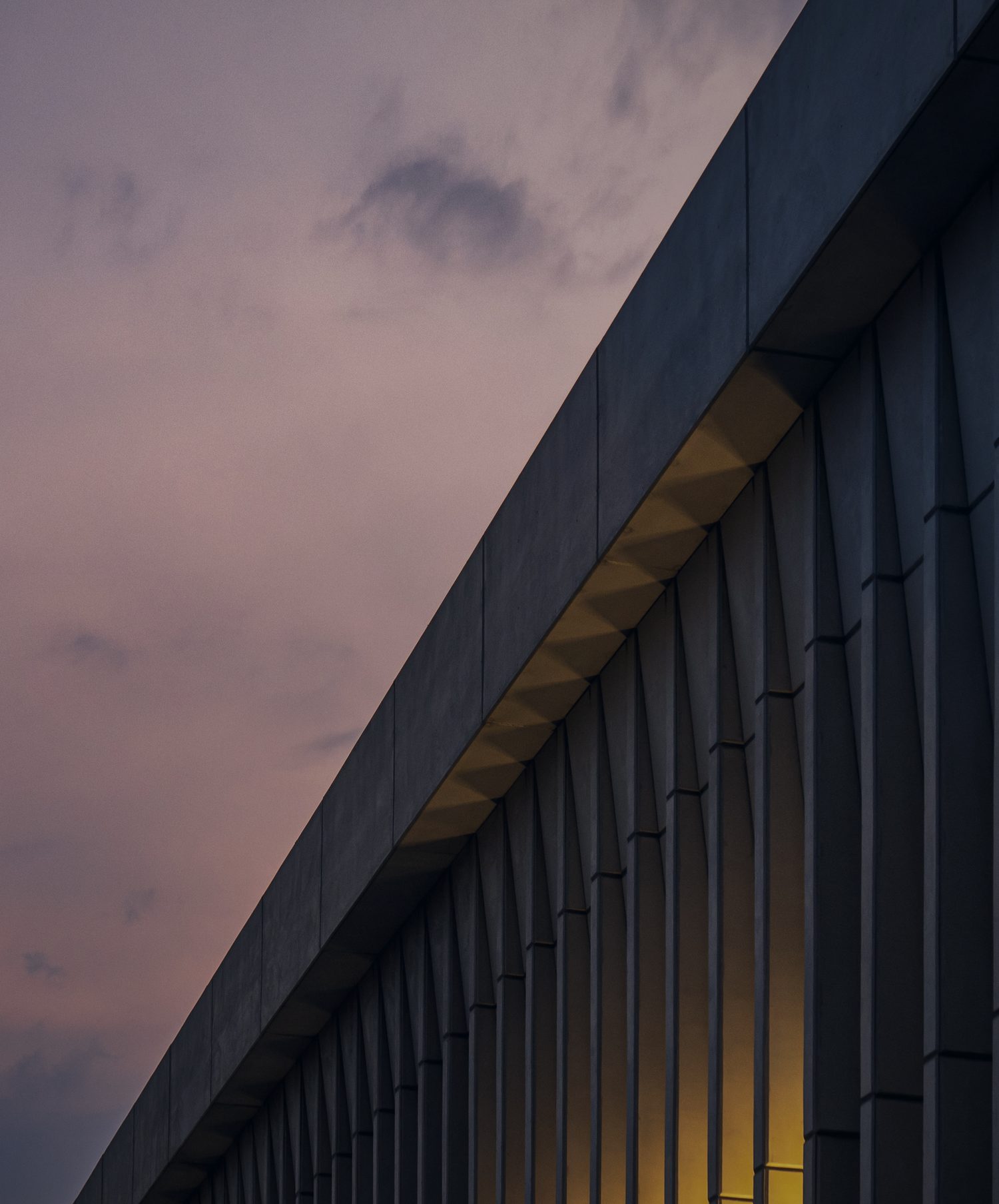 Geometric facade against a dusk sky